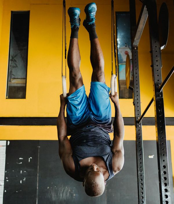 Man performing a controlled strength exercise in a modern gym.